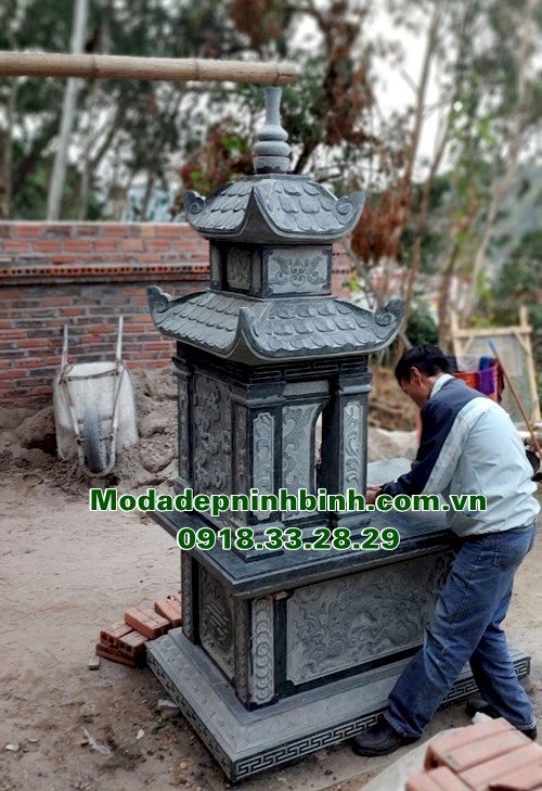 Hình ảnh thợ điêu khắc đá đang hoàn thiện lắp đặt mẫu mộ hai mái đá xanh rêu tại Quảng Ninh.