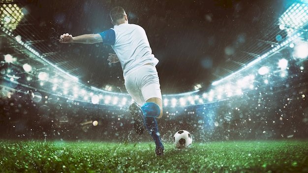 Cerca de una escena de fútbol en el partido de la noche con el jugador en  un uniforme blanco y azul pateando la pelota con poder | Foto Premium